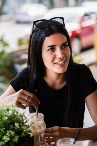 young indigenous woman having a coffee in a cafe - Australian Stock Image