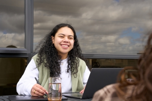 Young indigenous woman in study group with friend - Australian Stock Image