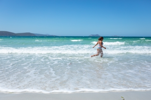 young lady running through the shallows on Middleton Beach - Australian Stock Image