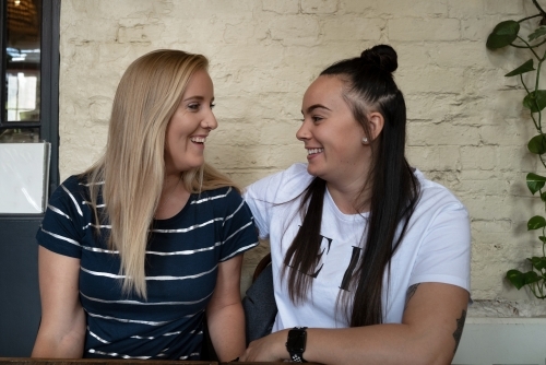 Young lesbian couple hanging out together in a coffee shop - Australian Stock Image