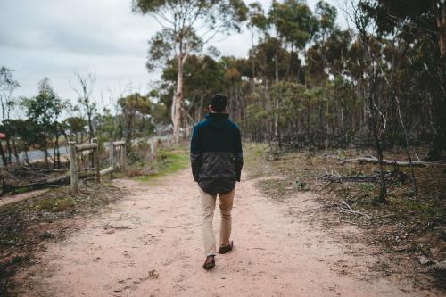 Young male walking in the bush from behind - Australian Stock Image