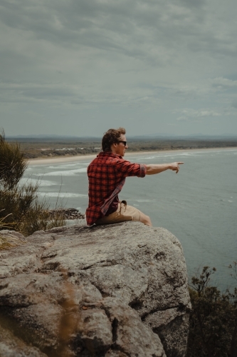 Young man at a lookout overlooking the beach and ocean at Evans Head. - Australian Stock Image