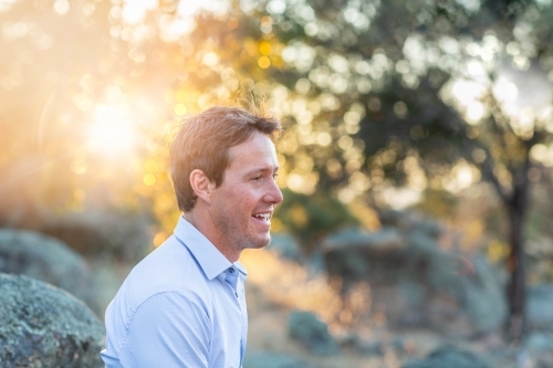 Young man in profile outdoors with sun flare