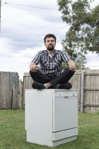 Young Man sitting on Dishwasher