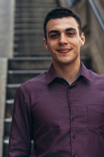 young man standing on the staircase smiling - Australian Stock Image