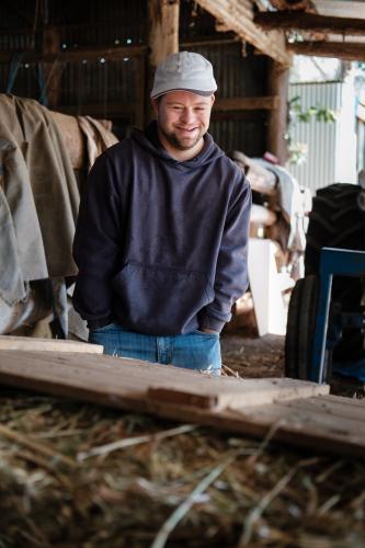 Young Man standing outside a Farm Shed