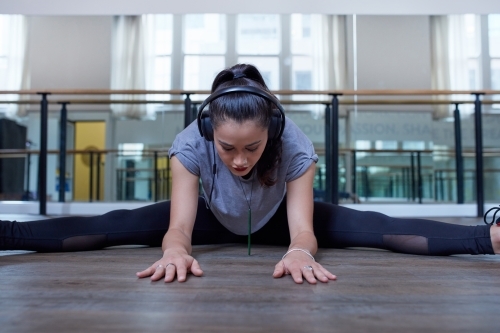 Young Maori dancer stretching at dance studio - Australian Stock Image