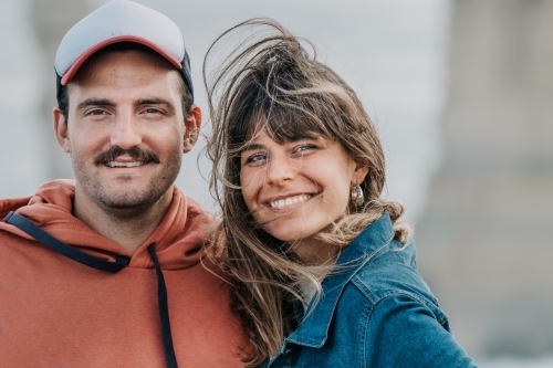 Young mid twenties couple smile in the wind. - Australian Stock Image