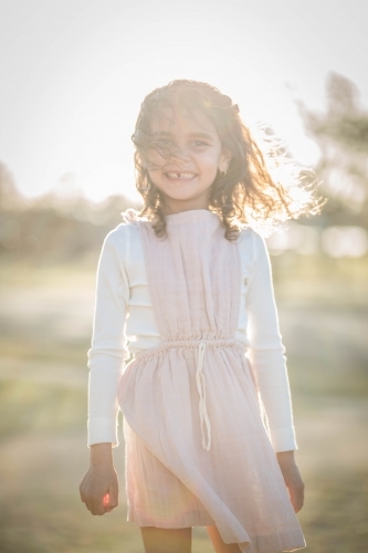 Young mixed race aboriginal and caucasian girl smiling in afternoon light - Australian Stock Image