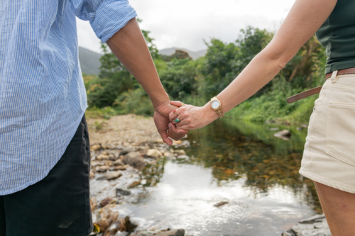 Young mixed race couple holding hands close-up on outdoor walk - Australian Stock Image