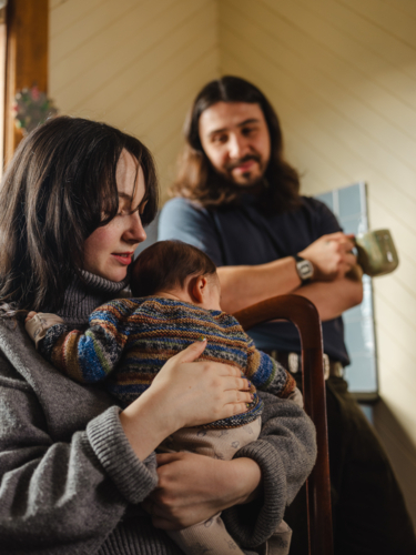 Young mother holding baby dressed in striped sweater - Australian Stock Image