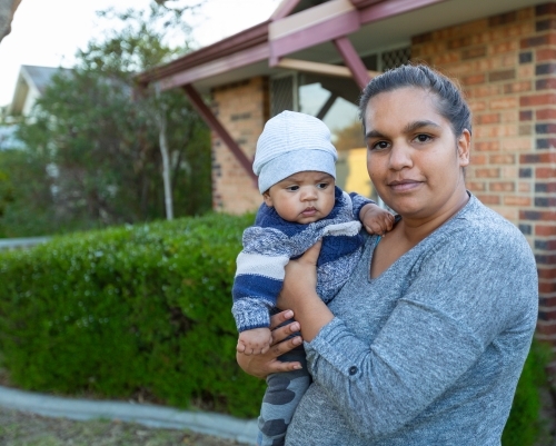 Young mother holding her baby outside - Australian Stock Image