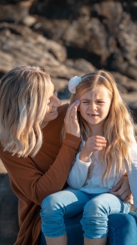 Young mother looking at daughter on beach - Australian Stock Image