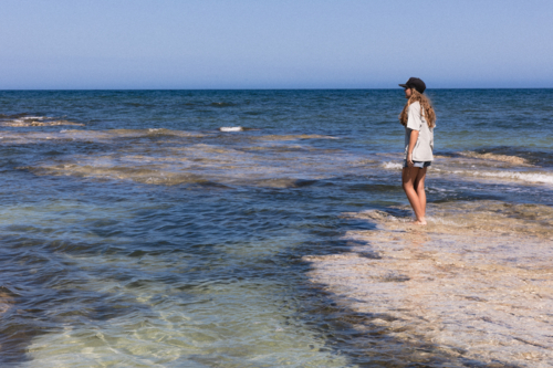 Young Person Standing in Shallow Water at Australian Beach - Australian Stock Image