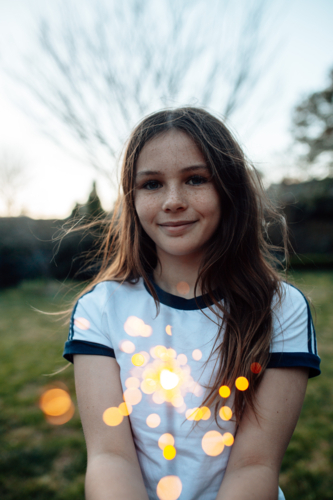 Young preteen girl holding a sparkler in the garden - Australian Stock Image