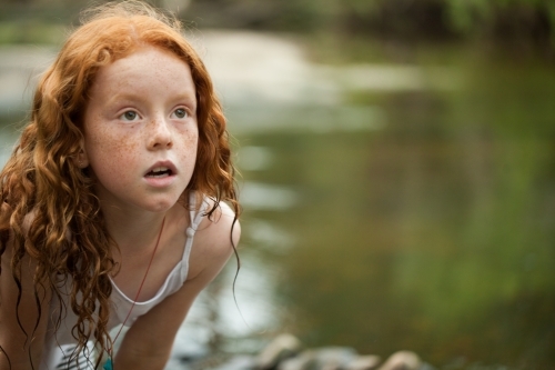 Young redheaded girl by the riverside - Australian Stock Image