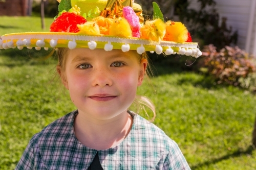 Young school girl wearing an Easter hat in the garden