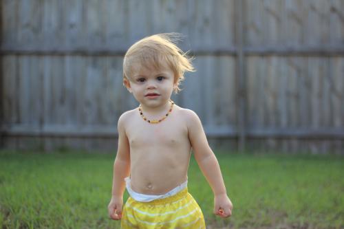 Young boy playing in a backyard, enjoying outdoor activity in a casual home setting - Australian Stock Image