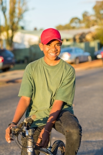 young teen sitting on bike in street - Australian Stock Image