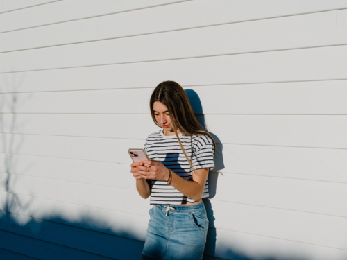 Young teenage girl holding a mobile device. - Australian Stock Image