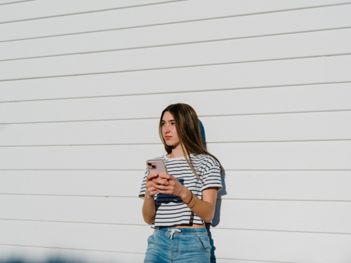 Young teenage girl holding a mobile device. - Australian Stock Image