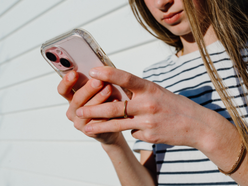 Young teenage girl holding a mobile device. - Australian Stock Image