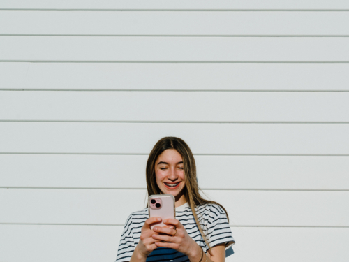 Young teenage girl taking selfies using her mobile device. - Australian Stock Image