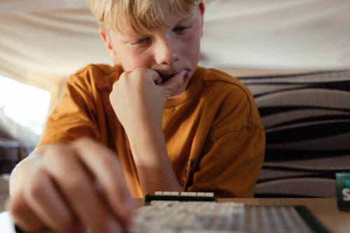 Young teenager thinking deeply about board game - Australian Stock Image