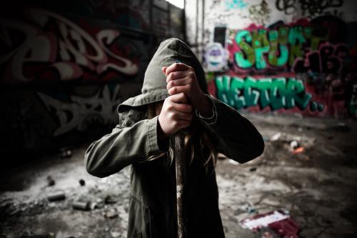 Young vandal holding a pipe in a pose of strength and defiance - Australian Stock Image