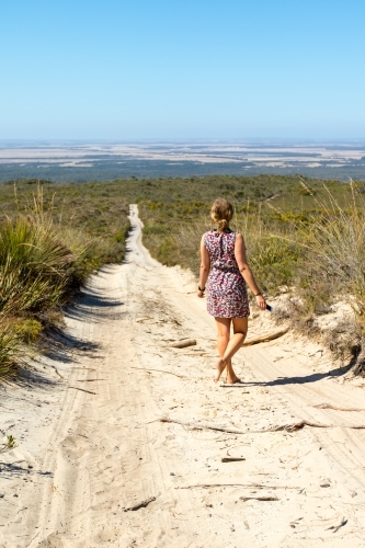 Young woman alone on sandy bush track
