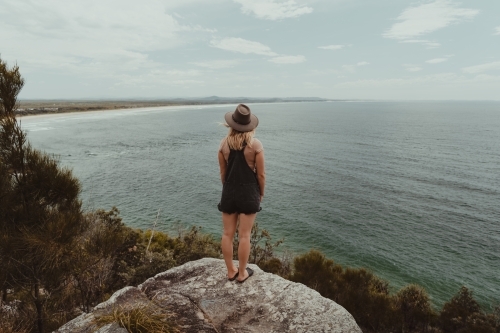 Young woman at a lookout overlooking the beach and ocean at Evans Head. - Australian Stock Image