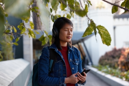 Young woman closing eyes listening to music - Australian Stock Image
