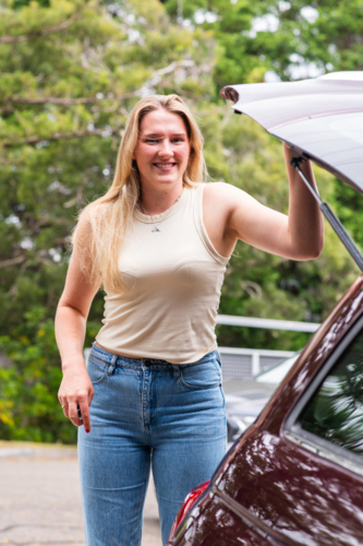young woman closing the hatch on her car - Australian Stock Image