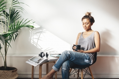 Young woman deep in thought holding a coffee with closed eyes - Australian Stock Image