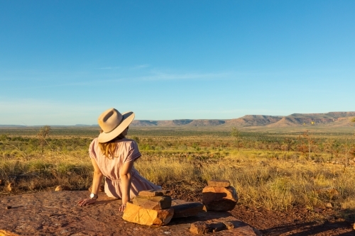 young woman from behind looking over valley towards Cockburn Range