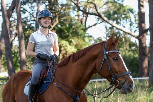 Young woman horse riding in park - Australian Stock Image