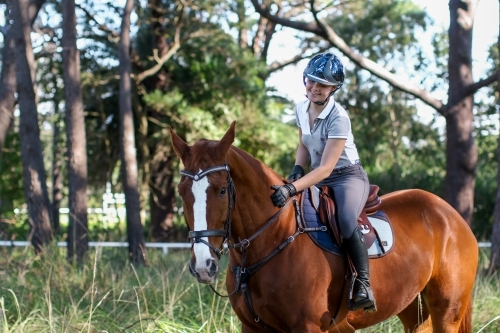Young woman horse riding in park - Australian Stock Image