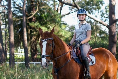 Young woman horse riding in park - Australian Stock Image