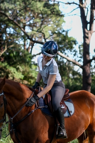Young woman horse riding in park