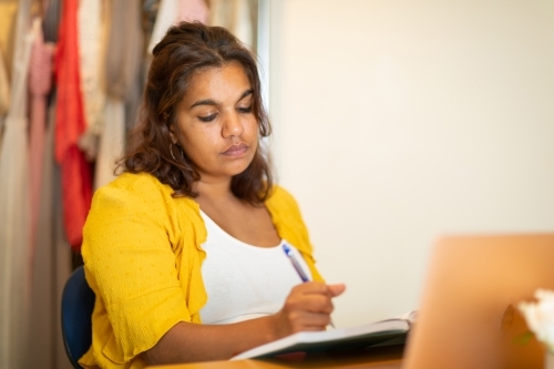 Young woman in home office doodling in home office - Australian Stock Image