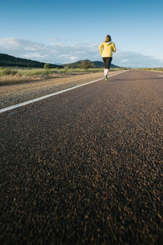 Young woman jogging on a country road