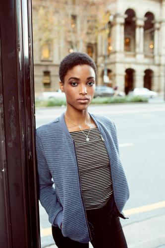 Young woman leaning on a pole on the street - Australian Stock Image