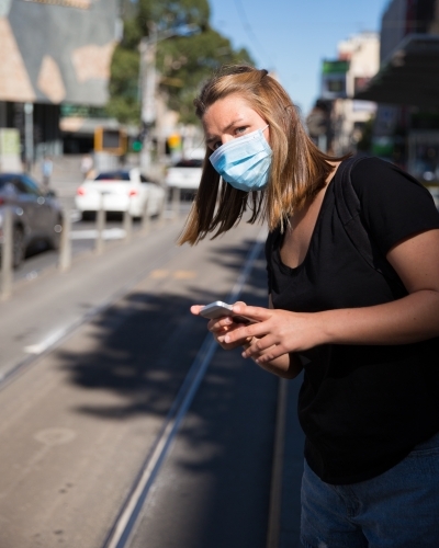 Young Woman Looking for the tram in Downtown Melbourne - Australian Stock Image