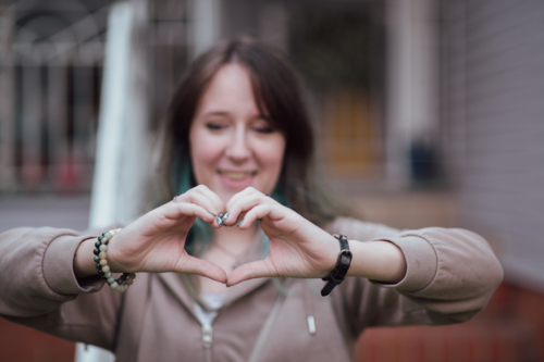 young woman making heart hands - Australian Stock Image