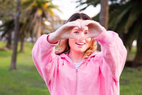 young woman making heart hands - Australian Stock Image