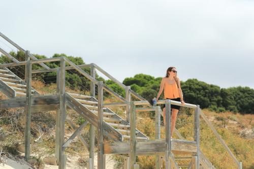 Young woman on wooden steps at the beach - Australian Stock Image