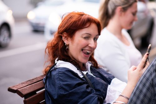 Young Woman Sitting on a Bench at a Busy Urban Intersection - Australian Stock Image