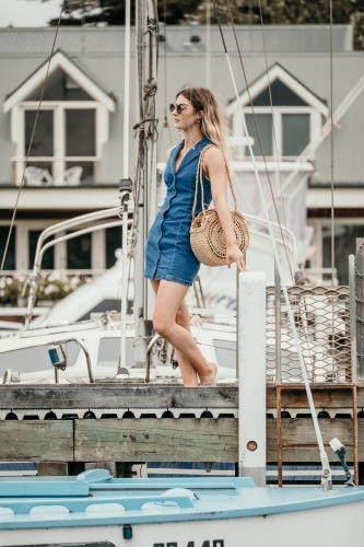 Young woman waiting at the boats on the jetty. - Australian Stock Image