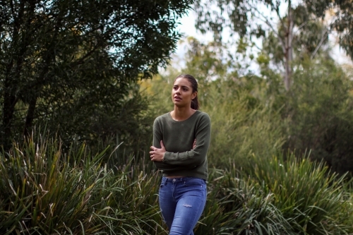 Young woman walking alone in outdoor setting - Australian Stock Image