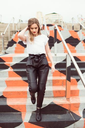 Young woman walking down stairs - Australian Stock Image